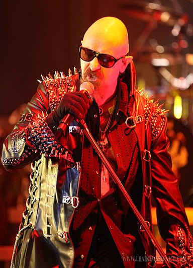 What is a key theme in many of Judas Priest's songs, reflecting Halford's style?